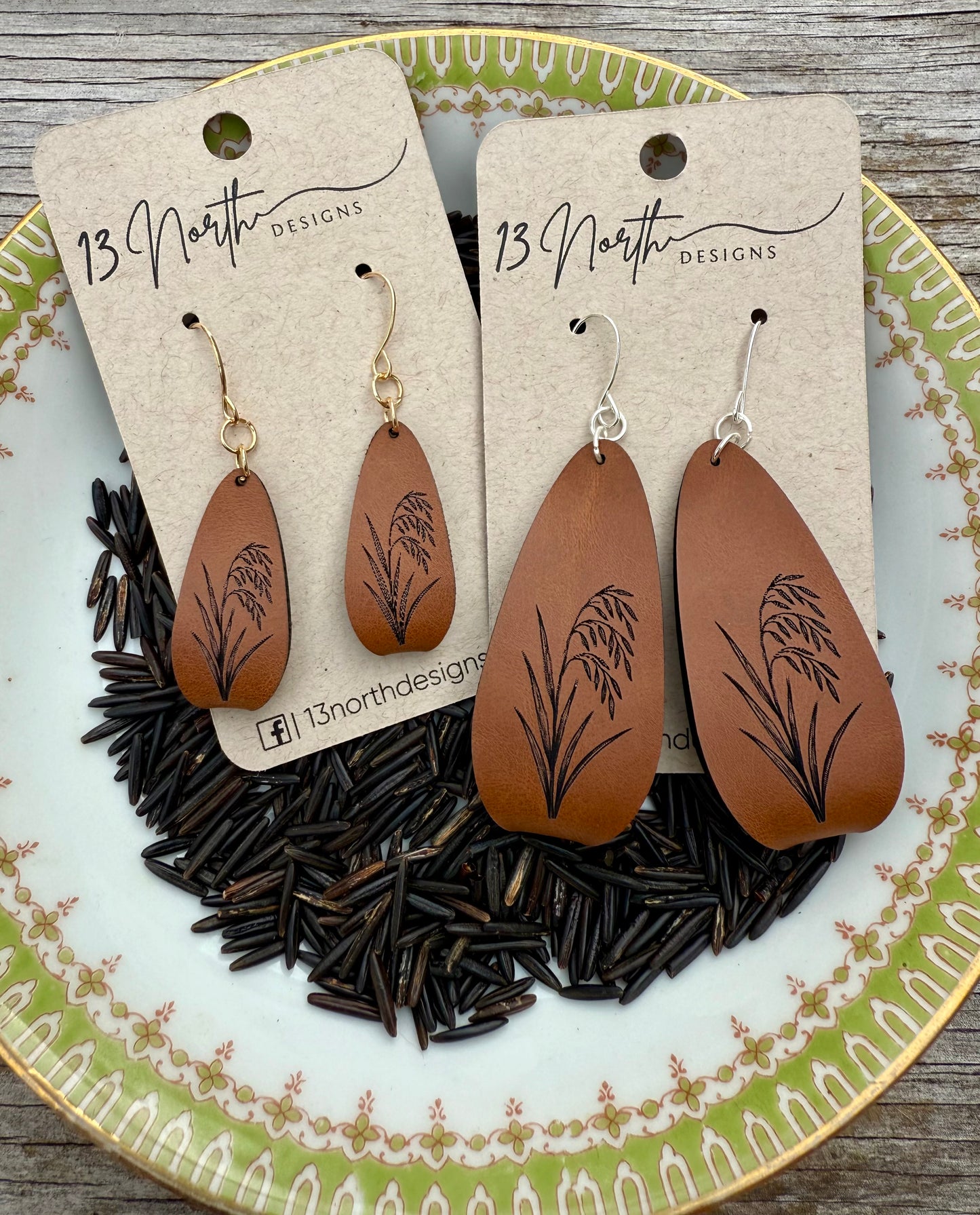 Brown leather earrings with Rice patterns on a '13 North Designs' card, displayed on a decorative plate.