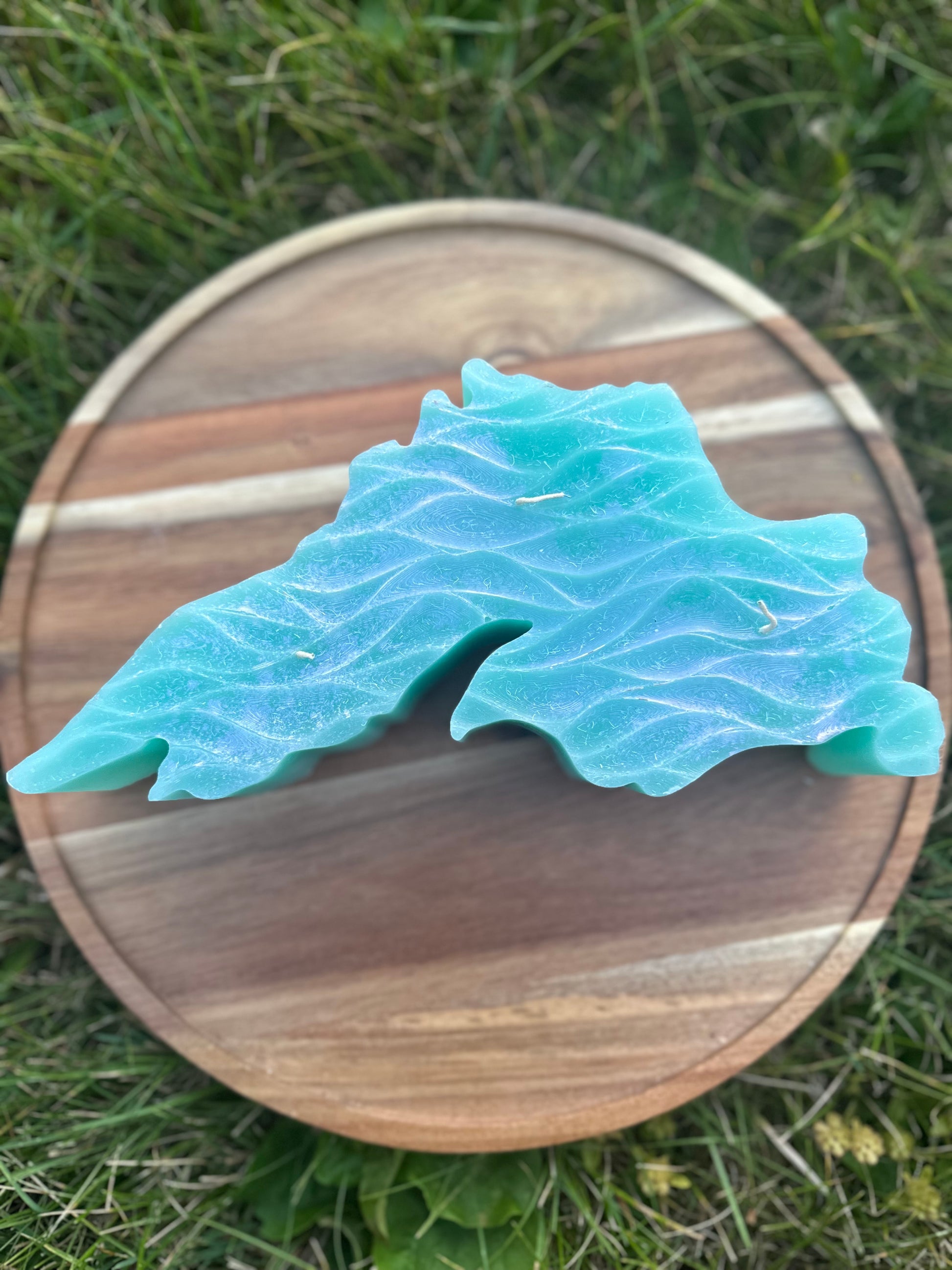 Aqua colored Lake Superior shaped candle with lake waves.